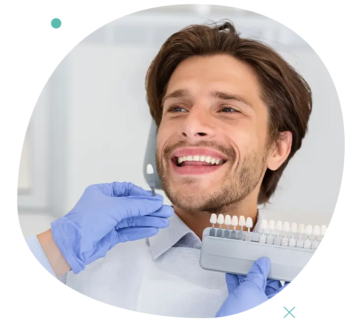 Uomo che sorride durante una procedura di sbiancamento dentale professionale
